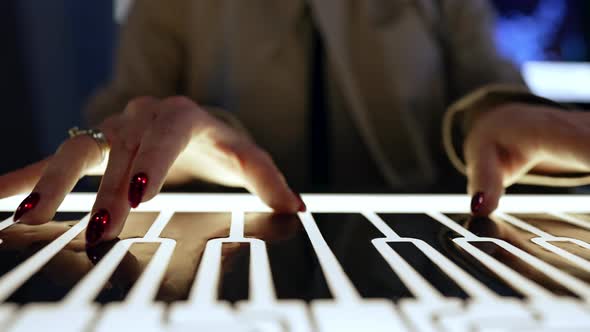 Woman Plays on Luminous Analog Piano Keyboard