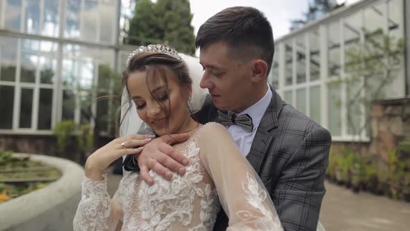 Newlyweds. Caucasian Groom with Bride Walking, Embracing, Hugs in Park. Wedding Couple