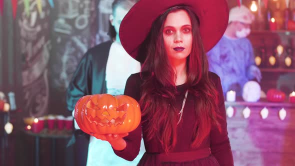 Young Beautiful Woman in Black Witch Costume at a Halloween Party