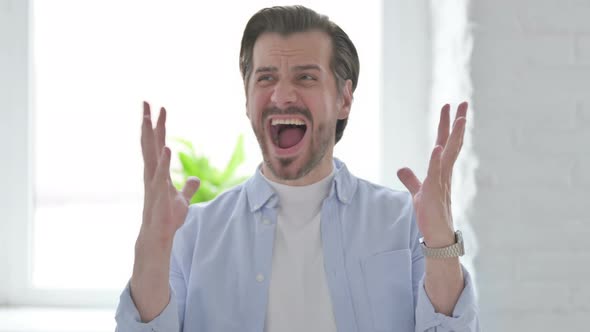 Portrait of Angry Young Man Screaming in Frustration