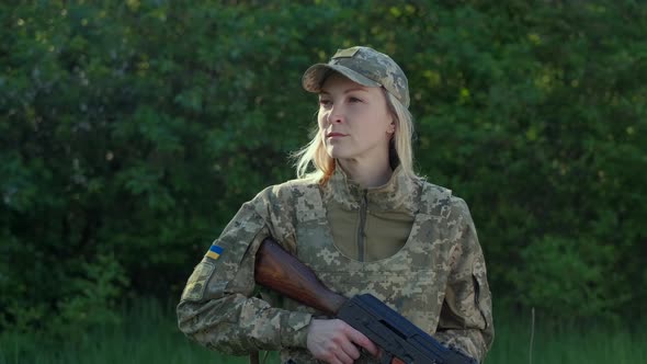 Portrait of Female Soldier in Camouflage Uniform Looking at Camera