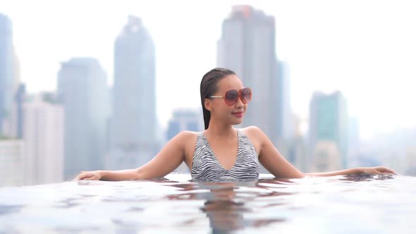 Young asian woman enjoy around outdoor swimming pool for leisure