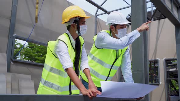 Asian colleague workers people wear protective safety helmet and face mask onsite of architecture.