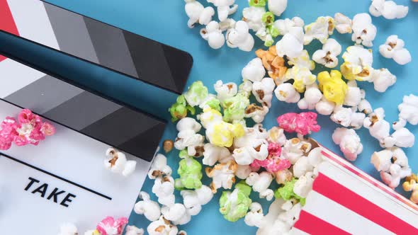 Movie Clapper Board and Popcorn on Blue Background