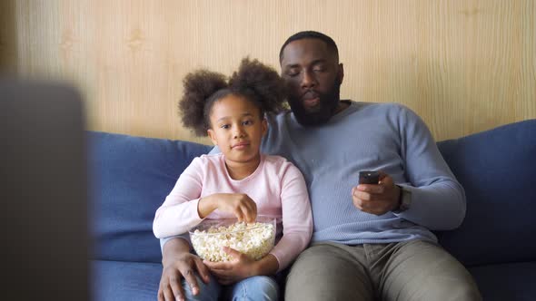 Cheerful African American Father and Mixraced Daughter Watching Tv at Home