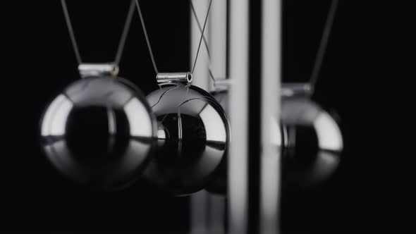 The balls of a Newtons Cradle colliding in slow motion
