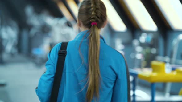 Woman in Sportswear Entering Gym with Bag on Shoulder