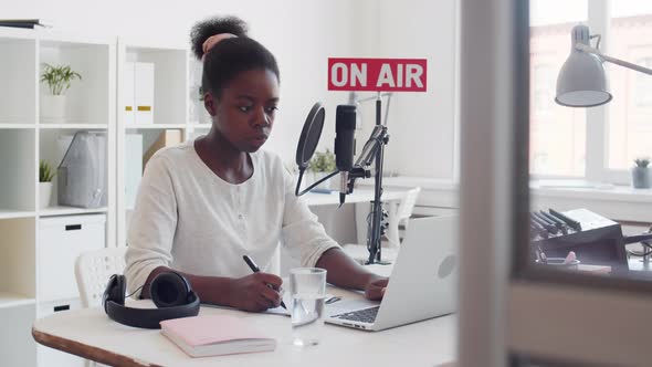 African Woman Preparing for Radio Broadcast