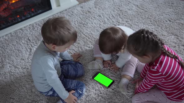 Adorable Cheerful Lucky Smart Joyful Toddler Children On Carpet Using Smartphone Green Screen Mobile