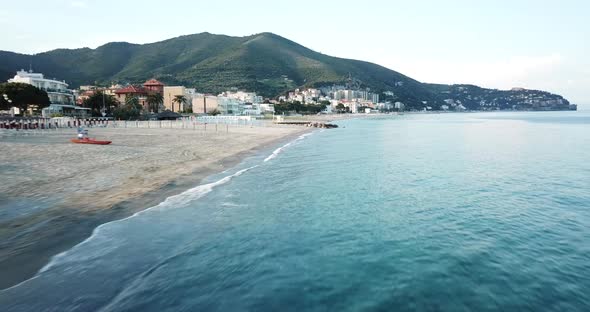 A drone flies parallel to the Mediterranean shore in Italy, in Genoa .aerial shot