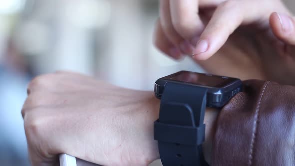 Woman Uses Modern Smart Clock On The Background Of People Walking