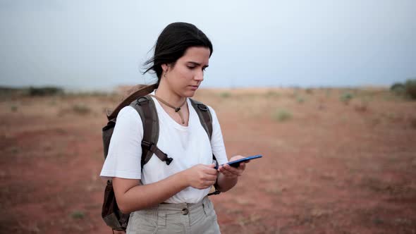 Woman using compass in desert