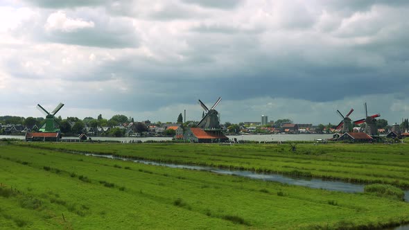 Windmills in a Rural Area, the Vanes Spin in the Wind, Building and the Cloudy Gray Sky