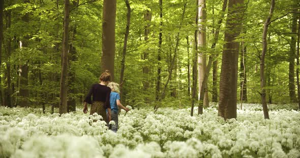 Siblings Carefully Watching Their Step While Surrounded By White Flowers