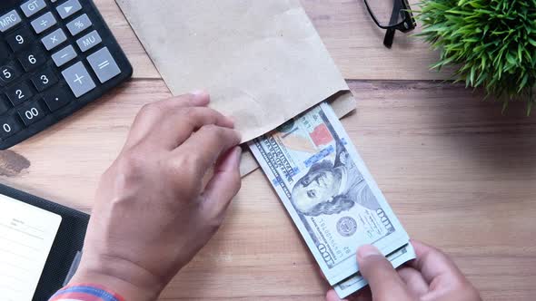 Person Hand Putting Cash in a Envelope.
