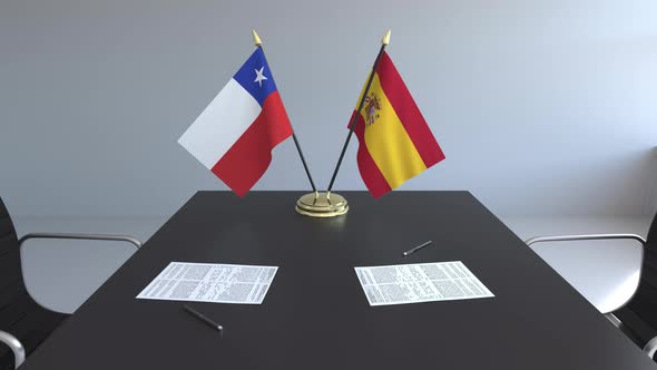 Flags of Chile and Spain and Papers on the Table