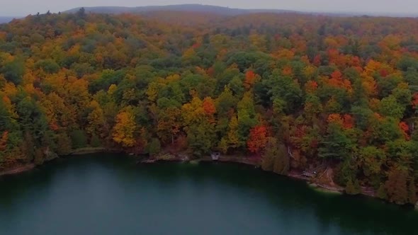 Beautiful drone shot of Pink Lake at Gatineau Park during the colorful Autumn season.