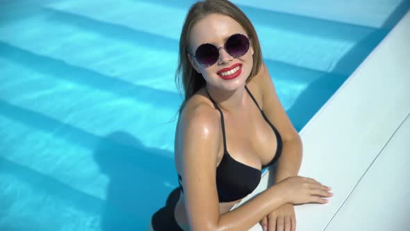 Sexy Female in Bikini Enjoying Summertime in Swimming Pool at Luxury Hotel