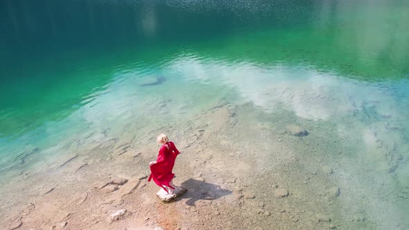 Woman in Red Dress Near Black Lake in Durmitor Mountains