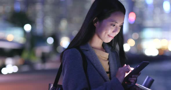 Young Woman use of mobile phone in Hong Kong at night