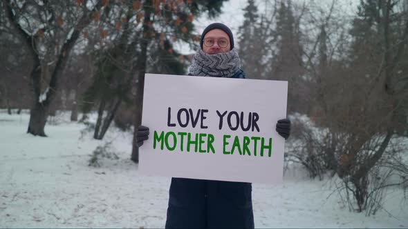 A Man is holding a banner Love Your Mother Earth to save the planet environment