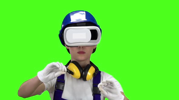 Builder Girl in Virtual Reality Glasses Plays an Interesting Game. Green Screen. Slow Motion