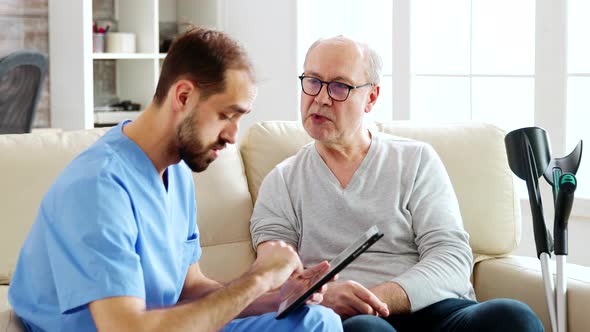 Caucasian Male Nurse Talking with a Nursing Home Patient About His Health