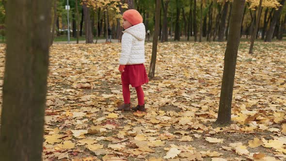 One Prettychild Kid Girl in Red Walking Alone in Park Forest Enjoying Autumn Fall Nature Weather