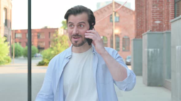 Man Getting Angry on Call While Walking in Street