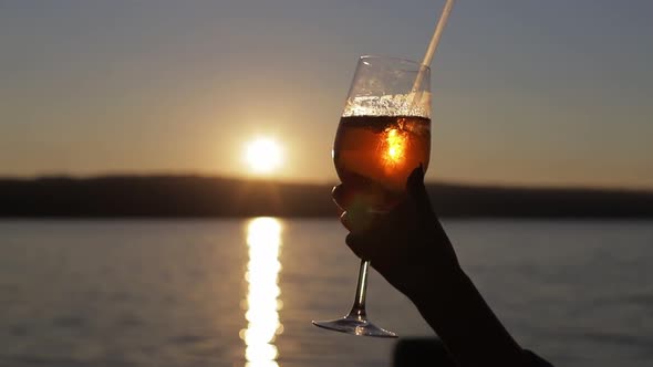 Female Blogger Takes Pictures of a Glass of Cocktail in a Cafe with Her Phone