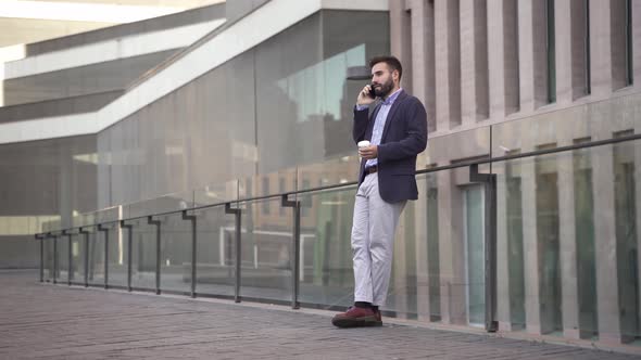 Young Middle East Businessman Talking on Phone in a Modern Corporate Business District