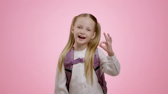 Adorable Little Schoolgirl with Backpack Showing Ok Gesture Approving Great Kids Stuff and Content