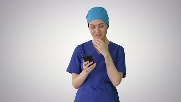 Thinking Female Doctor Using Her Smartphone on Gradient Background