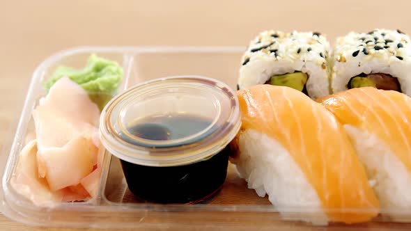 Sushi rolls with salmon in plastic container