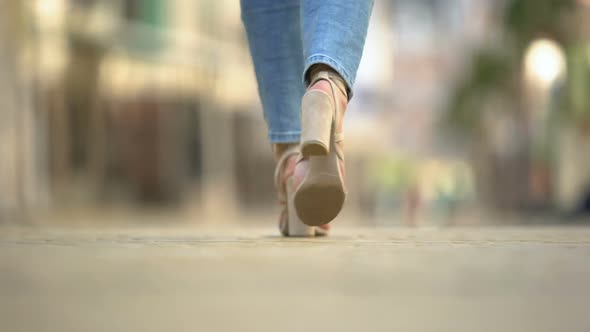 Fashionable Woman in Stylish High-Heeled Leather Sandals Walking Along Street