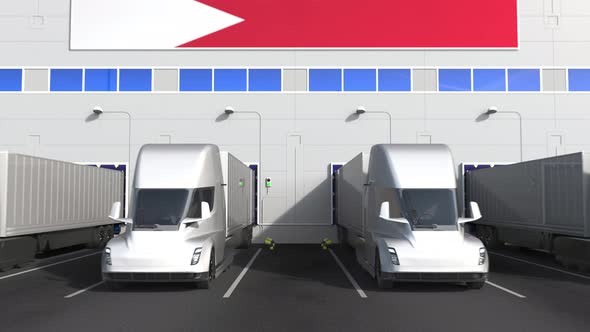 Electric Semitrailer Trucks at Warehouse Bay with Flag of BAHRAIN alt
