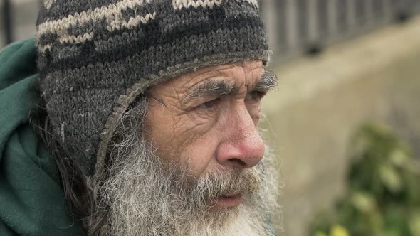 lonely old man in the street smoking: homeless, beggar, poor man