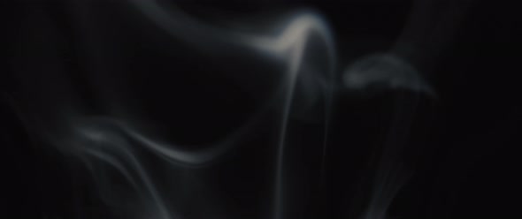 Beautiful incense smoke swirling on black background