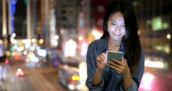 Woman using cellphone at night 