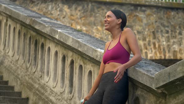 A woman takes a break after a workout to drink water