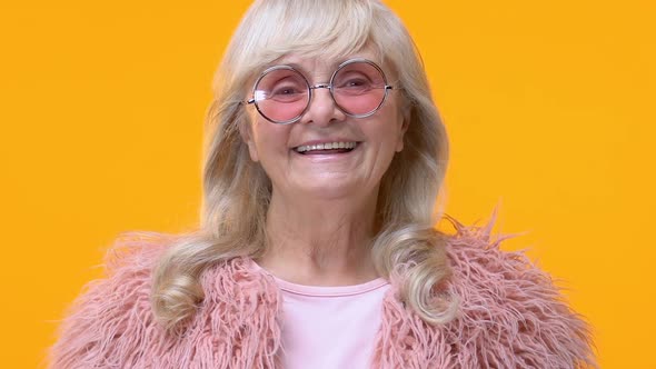 Modern Aged Woman in Pink Glasses Smiling Camera on Yellow Background, Glamour