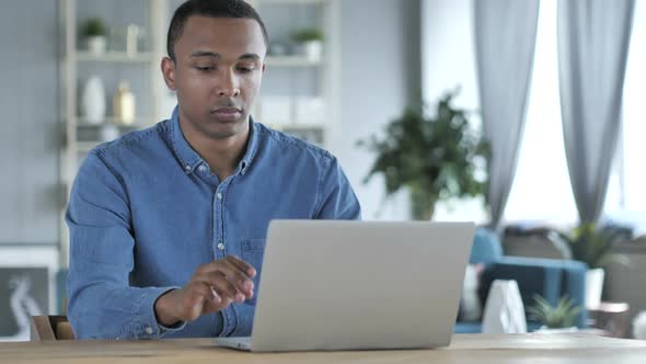 Young African Man Leaving After Working on Laptop