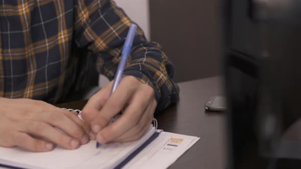 Left handed person writing on a notebook