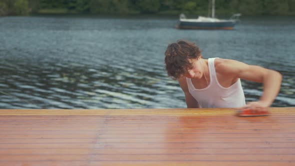 Hand sanding roof of wooden boat in Summer