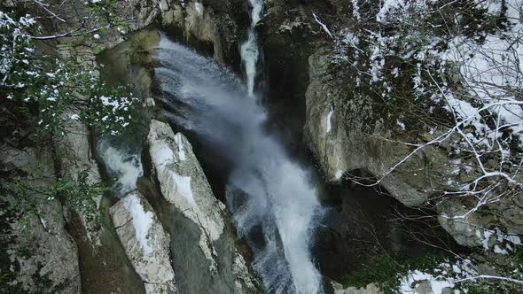 Waterfall Flowing From White Rocks Into a Lake in the Forest