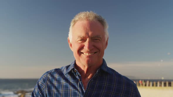 Front view of senior man in front of beach