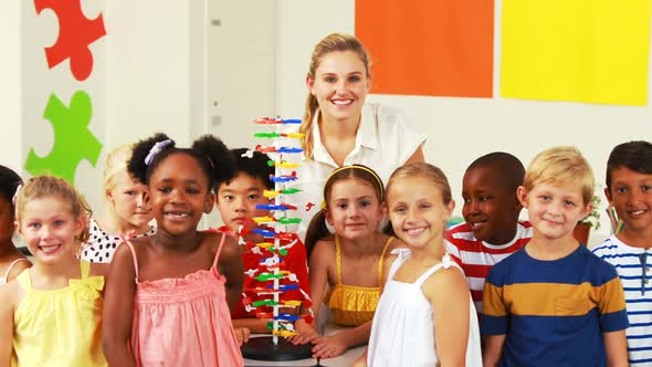 Portrait of kids and teacher doing thumbs up in laboratory