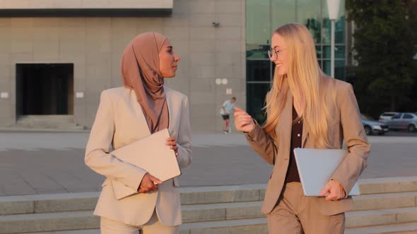 Businesswomen Indian Girl in Hijab and Young European Woman in Formal Clothes Finalizing