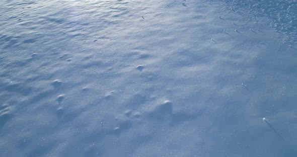 Forward Aerial Top View Over Winter Snowy Plain with Footprint in Sunny Day