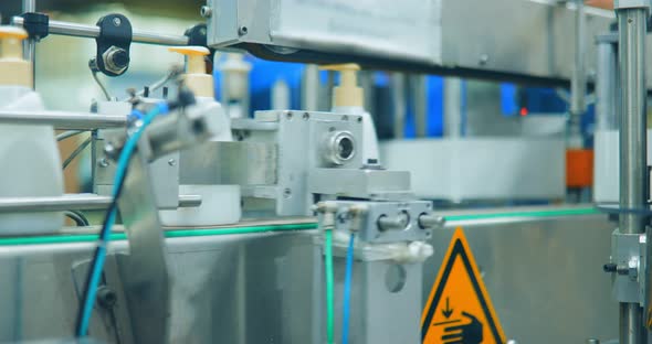 Row of White Plastic Bottles on the Conveyor Line of a Chemical Plant